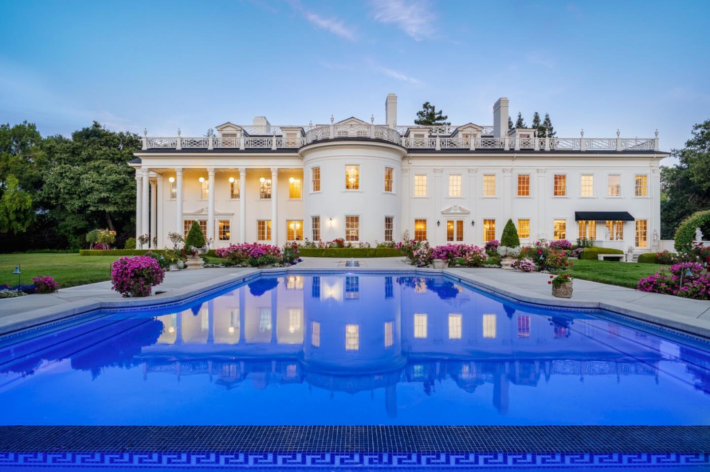 This opulent mansion stands as a veritable icon in Lower South Hillsborough, meticulously crafted as a homage to the White House by the esteemed architect Julia Morgan. Spanning over 24,000 square feet across four levels, it has been thoughtfully rejuvenated with the finest fixtures and state-of-the-art appliances. With its Neoclassical Georgian architecture, the home greets you with majestic columns and an impeccably laid driveway, the facade exuding grandeur. Inside, an abundance of windows and soaring ceilings invite the warmth of California's sun, bathing each room in natural light. Timeless accents such as intricate crown molding, resplendent wood floors, and dazzling chandeliers seamlessly marry with contemporary elements and sleek lines, epitomizing sophistication. Ascend to the primary bedroom, where a regal fireplace, a tranquil sitting area, and an opulent ensuite bathroom await, adorned with dual sinks, a sumptuous soaking tub, and a separate shower. A sanctuary for productivity, the home office boasts two-toned wood paneling and an imposing desk. Nestled upon nearly three acres of verdant grounds, the Bay Area's 'Western White House' is a testament to refined living and illustrious entertaining.