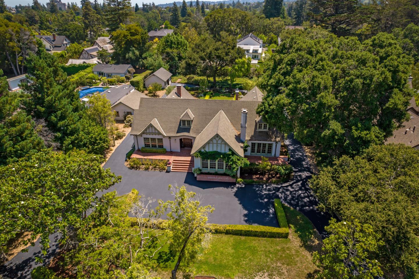 A Rare Opportunity: Iconic Estate on Nearly One Acre in Prestigious San Mateo Park! Rarely does a property of this magnitude become available in desired San Mateo Park! Located on nearly one acre of level grounds, and on the border of Hillsborough, this iconic estate boasts classic Tudor detail with roots dating back to 1924. A testament to earlier era craftmanship, the architecturally impressive home features beautiful hardwood floors, refined millwork, lofty ceilings, and tall true divided light windows throughout its generous one-level design. Expansive formal rooms, an oversized library with fireplace, office, and spacious kitchen with inviting breakfast room comprise the home's grand public spaces. There are three bedrooms, each with vintage tiled baths, plus a convenient half-bath. The vast rear grounds are landscaped in symmetry, adorned with manicured hedges, olive trees, and a large terrace for entertaining, all with a backdrop of lush foliage. A very special place in time!