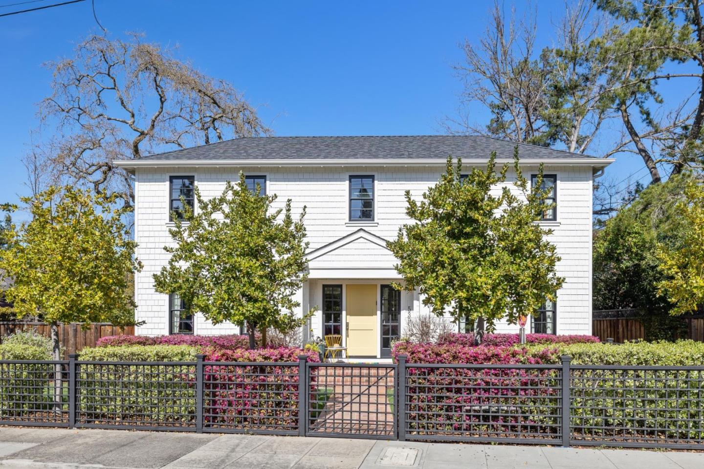 Located in the center of an exceptional street on the edge of Atherton, this stately Cape Cod Colonial-style home is a welcoming retreat for all who enter. The bright, light-filled entry with a central staircase and soaring ceilings is where it all begins. French oak flooring and high-end finishes are throughout this thoughtfully designed home.  The chef's kitchen and magnificent family room are indeed the heart of this home, offering an abundance of space for everyday living and entertaining. The open great room design with a dining area seamlessly connects to the outdoors through double French doors. The generous family room offers a cozy fireplace, custom window coverings, and views of the expansive, beautifully landscaped rear yard, featuring a sizeable custom-designed patio, market lights, and a firepit area.  The luxurious primary suite boasts vaulted ceilings, a spectacular light fixture, stunning finishes, and an impressive custom-designed walk-in closet.   The bathroom features a marble shower with dual shower heads, a marble vanity with double sinks, and a large soaking tub. A second primary suite on the ground floor is ideal for guests or extended family.  The other four bedrooms have private bathrooms, providing comfortable retreats for everyone. 4-car tandem garage.