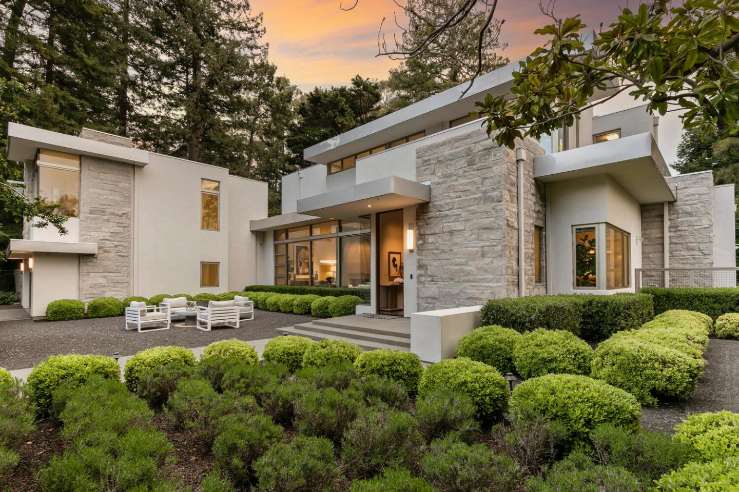 This modern masterpiece, built in 2018 embraces mid-century aesthetics and design principles in Lower Hillsborough on a secluded half-acre. Designed by Nancy Sheinholtz Associates, the home is surrounded by redwoods and features a modern facade of stainless steel and stone. Inside, polished concrete floors and glass walls underscore the modern vibe. The layout promotes indoor/outdoor living with retractable glass doors connecting the spacious great room to the outdoor pool area. The kitchen is a modern culinary space with top-tier appliances. There are 5 bedrooms, each with its own bath, plus an office. Main-level bedroom suite, upstairs primary suite and two additional suites, plus a private upstairs multi-room suite near an outside entrance offers flexibility for remote work needs or extended family/guest quarters. Outdoor entertainment is a breeze with a large pool, fire pit, and barbecue kitchen. Midway between San Francisco & Silicon Valley. Excellent public and private schools.