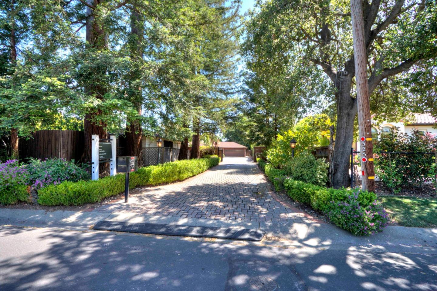 Discover the long redwood flanked paver driveway secluded in the luxuriant streetscape screening this estate-sized parcel near the Village. Beyond the mature redwoods the security gate rolls open to reveal a motorcourt with a sprawling 1970s style ranch home flanked by four garages, a workshop, and ADU. The main house of approximately 3345 SF includes 3 bedrooms, 3.5 baths, 3 HVAC zones, formal dining room, vaulted ceiling living room, quality appliances, steam shower, 3 fireplaces, wet bar, and theater room. The yard features a large pool, separate spa, lush mature landscaping, koi pond, waterfall, and extensive flagstone patios, ideal for large-scale entertaining in a very private setting. Convenient to top-rated Los Altos Schools. Buyer to rely on their own investigation of how new options SB9 may benefit this property.