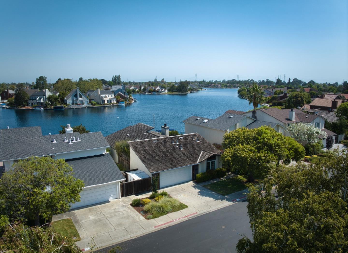 Nestled on the tranquil waterfront of Foster City, this elegant single-level home with three bedrooms and two bathrooms offers a serene retreat, providing the perfect blend of comfort and relaxation. Every detail reflects a comfortable, lived-in charm, from the designer paint to the sophisticated crown molding. High ceilings and double sliding doors add an airy, relaxed ambiance, while the wood-burning fireplace in the living room provides a cozy focal point along with picturesque views of the water. The formal dining area sets the stage for intimate gatherings, and the sunlit, large eat-in kitchen with high angled ceilings becomes a haven for culinary inspiration. The primary en-suite features a walk-in cedar-lined closet and direct access to the rear yard, offering a peaceful escape to unwind while gazing at the placid waterfront. This home epitomizes a lifestyle of unparalleled beauty and tranquility, with the soothing presence of the water always in view. Experience the vibrant Foster City lifestyle, surrounded by parks, top-rated schools, and convenient shopping options. Enjoy easy access to major highways CA-92 and US-101, making commuting a breeze.