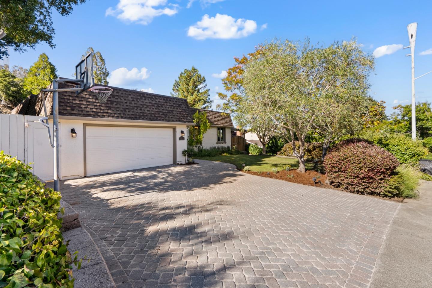 This one-story home is truly a treasure to be cherished! A sprawling, serene front yard features lush landscaping, large lawn area & mature shade trees. A secondary driveway boasts wide side yard access & versatile utilization options. Through a front garden gate, a bright foyer opens to a formal dining room which oversees a step-down living room with recessed lighting, crown molding, plush carpeting & access to the beautiful backyard. Adjacent to the dining room, a bright, elegant kitchen boasts a large island with countertop seating, granite countertops, stainless steel appliances & a soaring skylight that floods the space with natural light. The focal point is a charming, elevated fireplace in the eat-in area providing warm ambiance & inviting essences into the heart of the home. Just off the kitchen, an oversized family room with a cozy fireplace beckons for beloved moments & memories to be made with a built-in bar hosting a wine refrigerator, a large skylight &  glass patio doors to the outside deck. The primary suite features a spa-like sanctuary ensuite bathroom with double sinks, an air-jetted soaking tub & a spacious stall shower that provide a truly luxurious daily experience. Seize the opportunity to call this remarkable property your very own. Your dream home awaits!