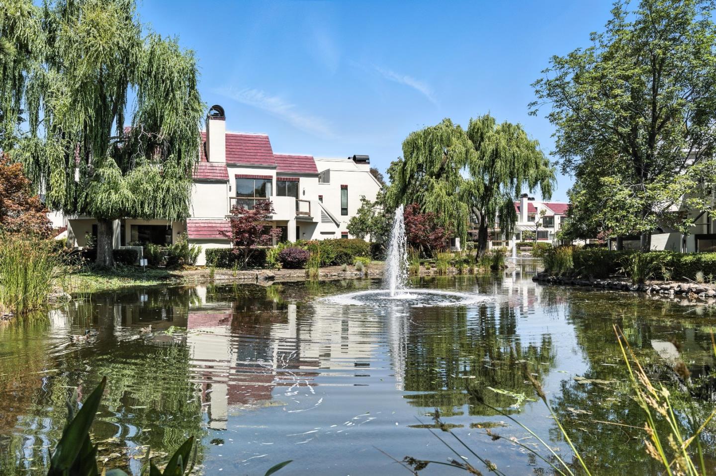 Wing it to 221 Shorebird Circle for a birds eye view of a willow-lined lake. This picturesque landscape is a welcome sight from the Great Room and bedrooms of this two-story, upper floor corner 2BD, 2BA condo. Go up the private exterior stairway to find an open plan layout:  living quarters, bathroom and primary bedroom downstairs; an ensuite loft upstairs. The great room showcases a vaulted ceiling, a sliding glass door out to a spacious wrap-around balcony, a wood-burning fireplace and a spiral staircase. Enjoy an al fresco lifestyle on the balcony: morning coffee off the bedroom, happy hour off the Great Room. The kitchen features an over-the-sink garden window and a pass-through breakfast bar. Spacious pantry is opposite an in-unit laundry. The aerie atop the spiral staircase can serve as an ensuite bedroom or home office or be turned into a hybrid: guest room/exercise room/arts studio/workshop/storage. The skys the limit. 2 assigned parking spaces. 2 pools and spas, clubhouse, kayak storage, boat launch. Nearby tennis courts, library, scenic trails, parks, birdwatching. Close to major commute routes,101, 92, 280, Belmont Caltrain, SFO, OAK, SJC. Beat the flock to Shorebird. Migrate to an airy perch in an oasis of serenity, overlooking water and willows. Happy landings.