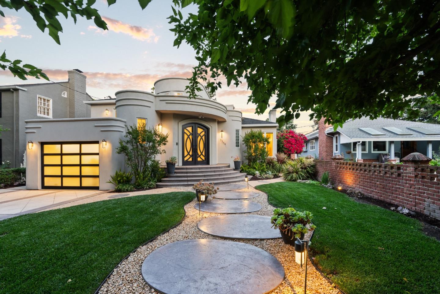 Set along the Rose Garden's most coveted and rarely available streets, 1344 University Ave is a masterfully rebuilt Art Deco Moderne residence blending architectural presence with refined modern living. Completely reimagined from the studs (2016/2017), the home spans 4,345 SF with 5 bedrooms and 5.5 baths on an expansive 11,500 SF lot. A dramatic 20-foot entry, heated limestone floors, arched skylight and sculptural curved staircase establish an immediate sense of scale & design intention. Principal living spaces balance grandeur & warmth, featuring ambient lighting, a limestone-clad fireplace and an oversized formal dining room. The chefs kitchen showcases quartzite surfaces, an 11-foot island, BlueStar range, Sub-Zero fridge & premium appliances. The family room seamlessly extends outdoors via Nano doors to a covered, heated veranda with fire feature. The primary suite offers a private retreat w/fireplace, custom walk-in closet and spa-inspired marble bath. Resort-style grounds include a sparkling saltwater pool/spa, outdoor kitchen, fire features, fountains and curated lounge spaces. Additional highlights: semi-finished basement, elevator, solar, water filtration & smart systems. A rare Rose Garden offering defined by craftsmanship, scale and timeless architectural character.